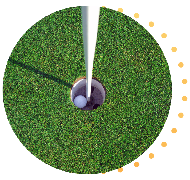 A close-up of a golf ball in the hole. 